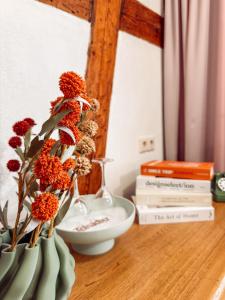 two vases with flowers on a table with books at Hotel Restaurant Ratsstube in Calw