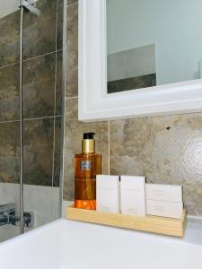 eine Flasche Seife auf einem Regal in einem Badezimmer in der Unterkunft Studio Satina Residence with Private Parking & Self Check-In in Craiova