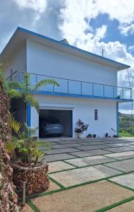 a white house with a car in the garage at Villa Carlito in Las Terrenas