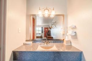 a bathroom with a sink and a mirror at Capital O Aurora Inn Monett US 60 in Aurora +26 photos