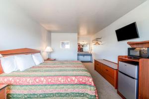 a hotel room with a bed and a microwave at Capital O Aurora Inn Monett US 60 in Aurora