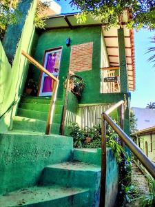 a green house with stairs in front of it at Varanda Suspensa em São Sebastião. in São Sebastião