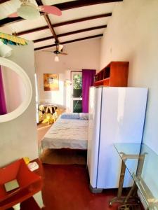 a bedroom with a bed and a refrigerator in it at Varanda Suspensa em São Sebastião. in São Sebastião +33 photos