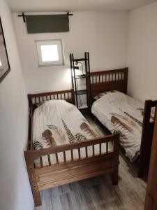 two twin beds in a room with a window at Béke Tanya in Nyársapát