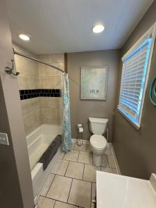 a bathroom with a toilet and a tub and a sink at Middle of It All only 30 min from Mammoth Cave! in Bowling Green +19 photos