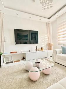 a white living room with a glass table and a couch at Tahrir Retreat in Cairo