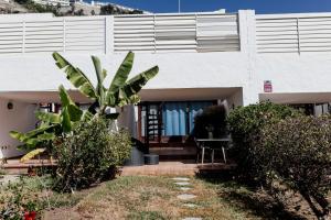 a house with a palm tree in front of it at Estancia - Bungalow en Puerto Rico in Puerto Rico de Gran Canaria