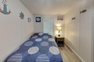 a small bedroom with a bed and a night stand at Island Club #101 in Put-in-Bay