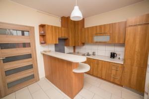 a kitchen with wooden cabinets and a counter top at Apartament Żaglowy nr 6 4osobowy in Puck