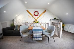 ブリクサムにあるHarbour View- Cosy Maisonette, Close to Brixham Harbourのテーブルと椅子2脚のあるダイニングルーム