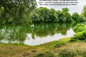 a picture of a river with trees and grass at RELAX HOUSE Kolpa view Podzemelj in Gradac