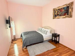 a bedroom with a bed and a painting on the wall at Apartment near Meidling in Vienna