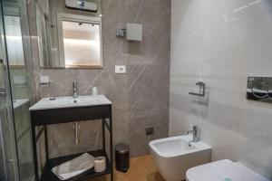 a bathroom with a sink and a toilet and a mirror at Flat Urban Suites in Rome