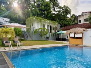 a swimming pool in front of a house at The Bunkyard Galle Hostel in Galle