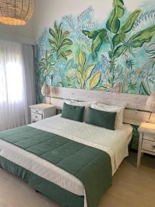 a bedroom with a large bed with a colorful wall at Pousada dos Girassóis in Pipa