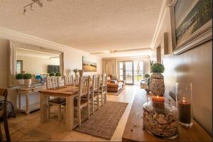 Una sala de estar con una mesa y un comedor. en Jeffreys Bay Beach Accommodation Waters Edge, en Jeffreys Bay