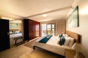 Un dormitorio con una cama grande y un balcón. en Jeffreys Bay Beach Accommodation Waters Edge, en Jeffreys Bay