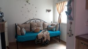 a blue bench with pillows on it in a room at La Terrazza Solarium, in pieno centro 60m dalla stazione ferroviaria 700m dal mare in Santa Flavia