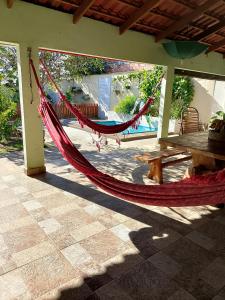 a hammock hanging on a patio with a table at Casa Andreia Borges in Aparecida de Goiania