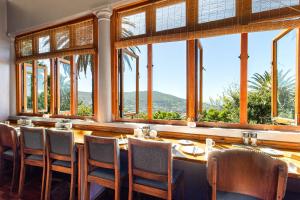 开普敦Redbourne Hilldrop Guesthouse B&B的一间带桌椅和窗户的用餐室