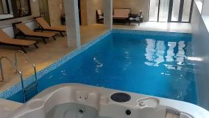 eine Badewanne in einem Badezimmer mit blauem Boden in der Unterkunft Hrebet House in Borowez