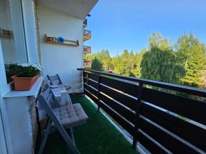 uma varanda com um banco e vista para as árvores em Apartmán Horný Smokovec em Vysoké Tatry