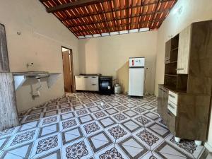 a kitchen with a tile floor and a refrigerator at Casa Sereia Guriu in Guriú