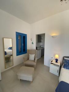 a bedroom with a bed and a chair and a mirror at Luxury studio on the beach in Ios Chora +26 photos
