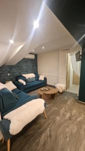 a living room with a blue couch and a table at Chambre Heïdi dans le loft bleu in Sablons +5 photos