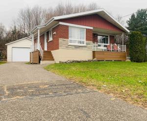 a house with a driveway in front of it at Cottage de style Loft in Saint-Charles-des-Grondines