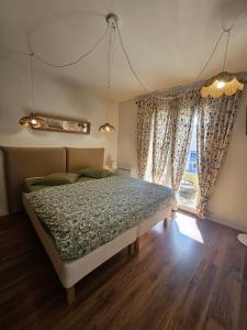 a bedroom with a bed and a window with curtains at Chambre Heïdi dans le loft bleu in Sablons