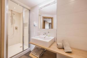 a white bathroom with a sink and a shower at Pension Gabl in Pfunds
