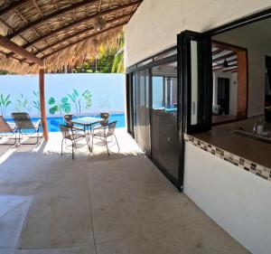 un patio avec une table et des chaises et l'océan dans l'établissement Casa Bugambilia - Santa Cruz, à Santa Cruz Huatulco