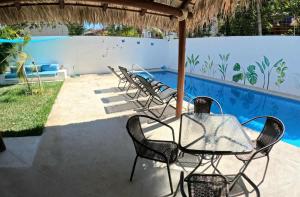 une table et des chaises sous un parasol à côté d'une piscine dans l'établissement Casa Bugambilia - Santa Cruz, à Santa Cruz Huatulco 38 autres photos