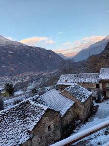 a group of buildings with snow on the roofs at La vetta del gufo in Settimo Vittone