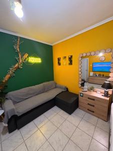 a bedroom with a bed and a desk and a mirror at Tropical studio - myHomee in Xanthi