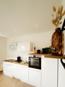 una cucina con armadi bianchi e un vaso di fiori di neue 90qm Ferienwohnung mit 3 Schlafzimmern in Seenähe a Pouch