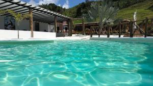 a pool of blue water in front of a building at finca hotel ganbaru in Guática