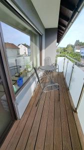 a balcony with two chairs and a table and a window at Wohnung Brand in Neumarkt in der Oberpfalz