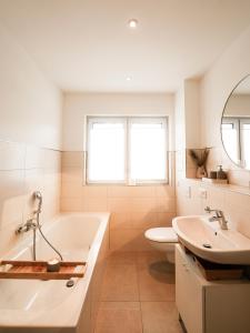 un bagno con vasca, WC e lavandino di neue 90qm Ferienwohnung mit 3 Schlafzimmern in Seenähe a Pouch Altre 14 foto