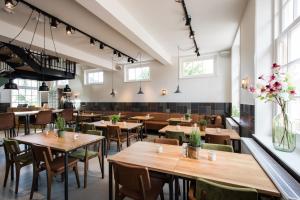 a restaurant with wooden tables and chairs and windows at Boutique Hotel d'Oude Morsch in Leiden +47 photos