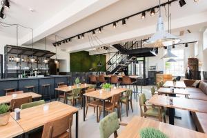 an empty restaurant with wooden tables and chairs at Boutique Hotel d'Oude Morsch in Leiden