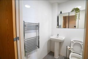 łazienka z umywalką, toaletą i lustrem w obiekcie Luxury Swindon Centre Apartment 3 min to Train Station w mieście Swindon +17 zdjęć