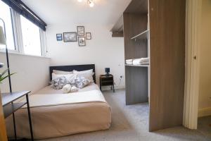 mała sypialnia z łóżkiem i oknem w obiekcie Luxury Swindon Centre Apartment 3 min to Train Station w mieście Swindon