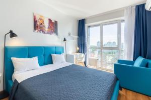 Un dormitorio con una cama azul y una silla azul. en Petrovdom Apartments 20-199в in RC Kvartet, 16г Lypkivskoho Street, en Kiev