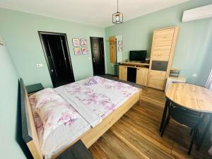 a bedroom with a large bed and a table at Vyara apartments 56 in Varna City +17 photos