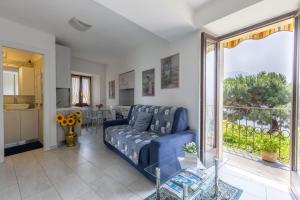 a living room with a blue couch and a kitchen at Appartamento Francisca, Domaso, Como Lake in Domaso