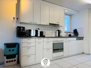 a kitchen with white cabinets and a microwave at Family M Apartments 40 - Luzern - Horw in Luzern
