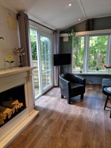 un soggiorno con camino e sedia di Chalet Vakantie Wageningen Veluwe a Wageningen