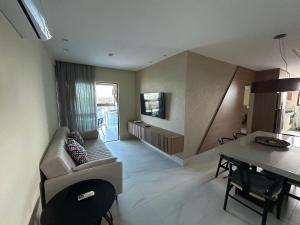 ein Wohnzimmer mit Sofa und Tisch in der Unterkunft Apartamento 40m da praia Maragogi vista mar in Maragogi